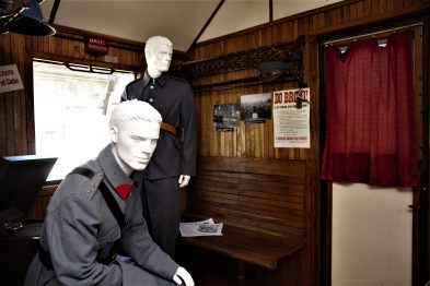 Wnętrze starego wagonu pasażerskiego jest urządzone w stylu epoki, na ścianach widać drewniane obicie. Dwa manekiny ubrane w stroje z początku XX wieku siedzą naprzeciwko siebie; jeden w mundurze, drugi w cywilnym ubraniu. Przy oknie wisi czerwona zasłona, a obok manekina w mundurze widoczny jest stary plakat z napisami.