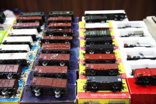 Na wystawie prezentowane są modele kolejowe ustawione w rzędach na stoisku, umieszczone na blacie stołu. Modele lokomotyw i wagonów są różnorodne, mają różne kolory i są umieszczone na kolorowych opakowaniach. Miniatury kolejek wydają się być szczegółowe i kolekcjonerskie.