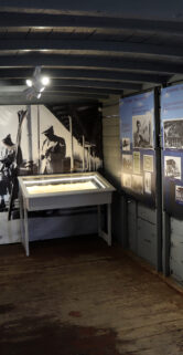 Wnętrze pomieszczenia przypomina wagon kolejowy, z wystawą zdjęć i pamiątek kolejowych na ścianach. Centralne miejsce zajmuje gablota z eksponatami, a ściany zdobią liczne czarno-białe fotografie. Oświetlenie podkreśla ekspozycję, skupiając uwagę na historycznych aspektach kolei w Zakopanem.