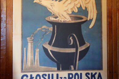 Plakat propagandowy przedstawia biało-czerwone skrzydła wychodzące z parującego kociołka. Nadrukowane hasło głosi: 