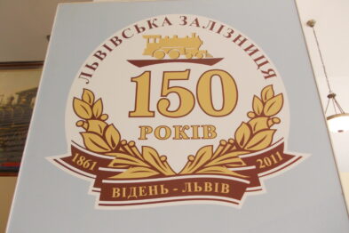 Tablica upamiętniająca 150-lecie kolei we Lwowie zawiera zapisy w języku ukraińskim oraz rok założenia 1861 i datę rocznicową 2011, umieszczone są po bokach wiązanki laurowej. Centralnej części tablicy dominuje wielka liczba 