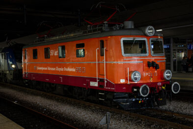 Pomarańczowa lokomotywa elektryczna oznaczona jest napisem 