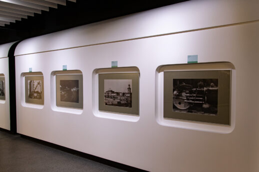 Pięć czarno-białych fotografii o tematyce kolejowej jest zawieszonych w równych odstępach na jasnej ścianie galerii. Fotografie są oprawione w pasujące ramki i mają dedykowane oświetlenie, które podkreśla szczegóły i jakość każdego dzieła. Pod każdym zdjęciem umieszczono informację o autorze i tytule prac.