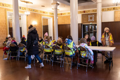 Zajęcia z warsztatów zimowych. Dzieci siedzące na sali lustrzanej przy stel.