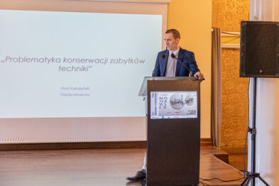 Prelegent stoi przy mównicy i wygłasza wykład