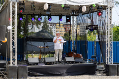 Pan sam stoi na środku sceny i mówi do mikrofonu