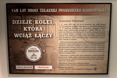 Plansza wystawowa upamiętniająca 140-lecie Drogi Żelaznej Iwangrodzko-Dąbrowskiej, znajdująca się w Stacji Muzeum. W tle historyczne zdjęcie kolejarzy. Tytuł planszy: „Dzieje kolei, która wciąż łączy”. Tekst opisuje znaczenie otwarcia linii kolejowej w 1885 roku, która połączyła Zagłębie Dąbrowskie z wschodnimi guberniami Królestwa Polskiego. Wspomniano o inwestorze Janie Gotlibie Blochu, roli kolei w rozwoju gospodarczym i społecznym oraz o współczesnym znaczeniu tej trasy. Na dole planszy logo „Stacja Muzeum” i „Mazowsze. Serce Polski”. W centralnej części emblemat z napisem „140 lat Drogi Żelaznej Iwangrodzko-Dąbrowskiej 1885–2025”.