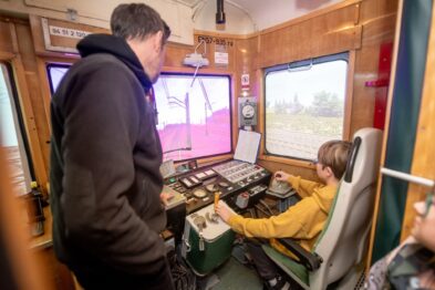 Wnętrze symulatora jazdy pociągu, w środku 2 osoby