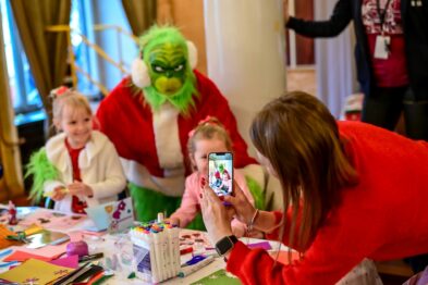 Dzieci robią sobie zdjęcie z postacią w stroju Grincha