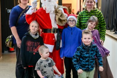 Ludzie pozują do zdjęcia ze św. Mikołajem