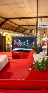 Dziecko w goglach vr na głowie siedzi w saniach obok telewizor