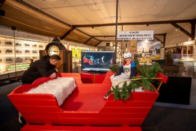 Dziecko w goglach vr na głowie siedzi w saniach obok telewizor