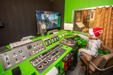 Dziecko w świątecznej czapce w symulatorze lokomotywy