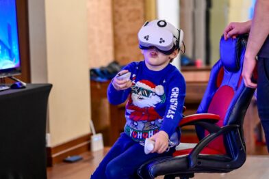 Dziecko w goglach vr na głowie siedzi na krześle