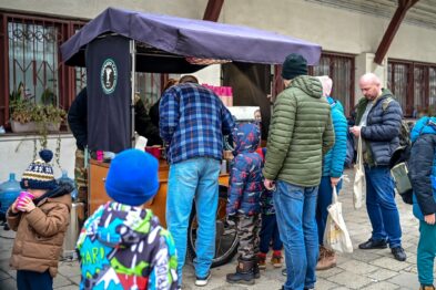 Zwiedzający przy stoisku z kawą i herbatą