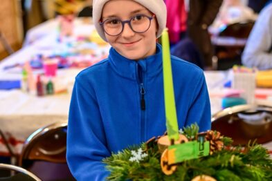 Chłopiec pozuje ze stroikiem światecznym