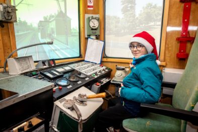 Dziecko w świątecznej czapce w symulatorze lokomotywy