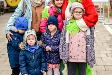 Dzieci robią sobie zdjęcie z postacią w stroju Grincha