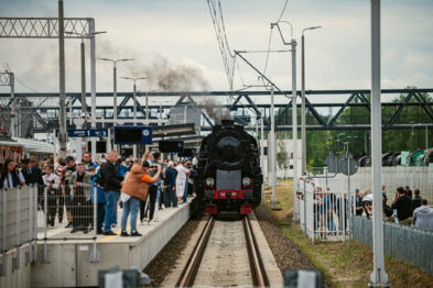 Zabytkowy parowóz stoi przy peronie stacji Warszawa Główna. Wokół zgromadzili się pasażerowie i miłośnicy kolei obserwujący historyczny skład