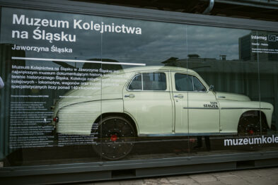 Zabytkowy samochód kolejowy prezentowany jest w przeszklonej gablocie z informacjami o Muzeum Kolejnictwa na Śląsku w Jaworzynie Śląskiej