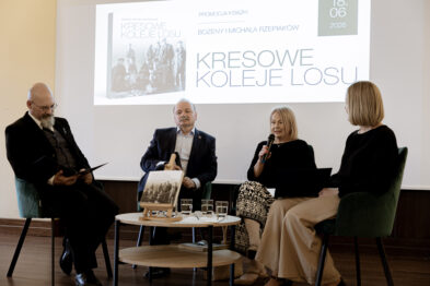Panel dyskusyjny z udziałem czterech osób. Na ekranie w tle widoczna jest prezentacja książki „Kresowe koleje losu”, której egzemplarz stoi na stoliku przed uczestnikami.