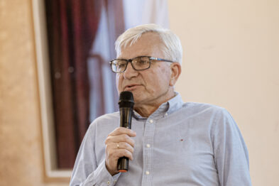 Mężczyzna z mikrofonem zadający pytanie z widowni.