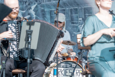 Muzycy występują na scenie podczas koncertu plenerowego.