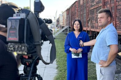 Kobieta w niebieskim stroju udziela wywiadu do telewizji