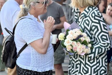 Kobieta z kwiatami rozmawia z inną kobietą