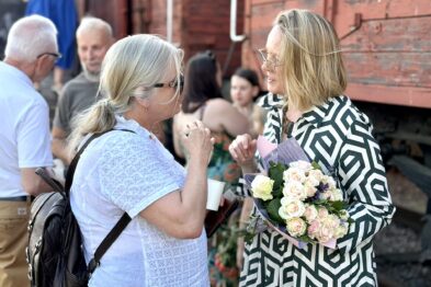 Kobieta z kwiatami rozmawia z inną kobietą