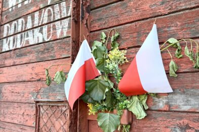 Wagon towarowy z biało-czerwonymi flagami